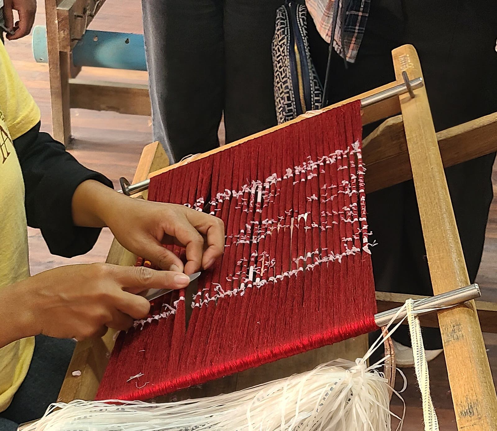 A silk weaver at Artisans Angkor removes the ties from ikat-dyed threads before weaving.