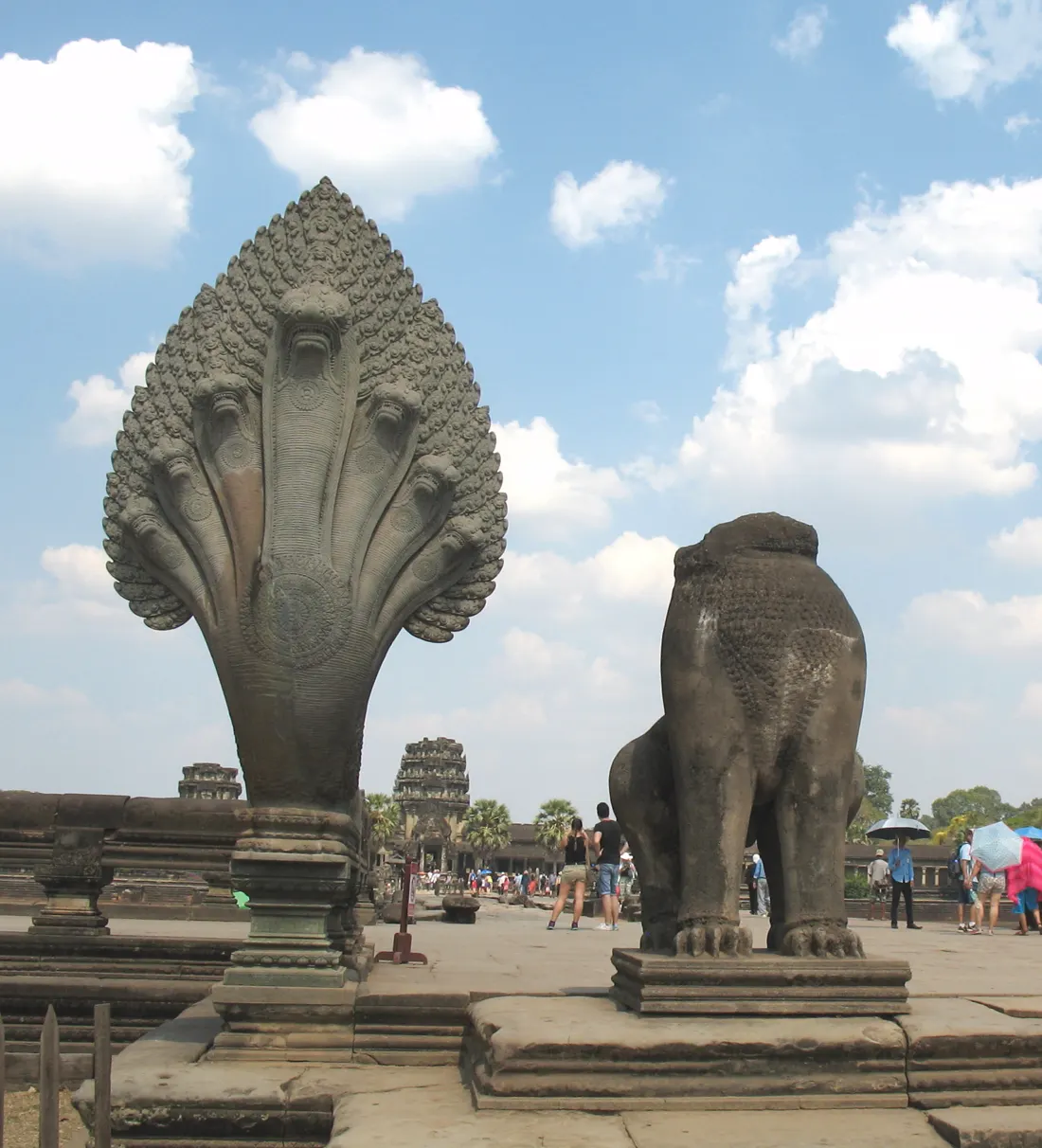 A naga balustrade and a guardian lion beside the causeway at Angkor Wat.